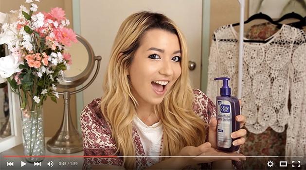 youtube star maybaby smiling with a clean and clear acne product in her hand